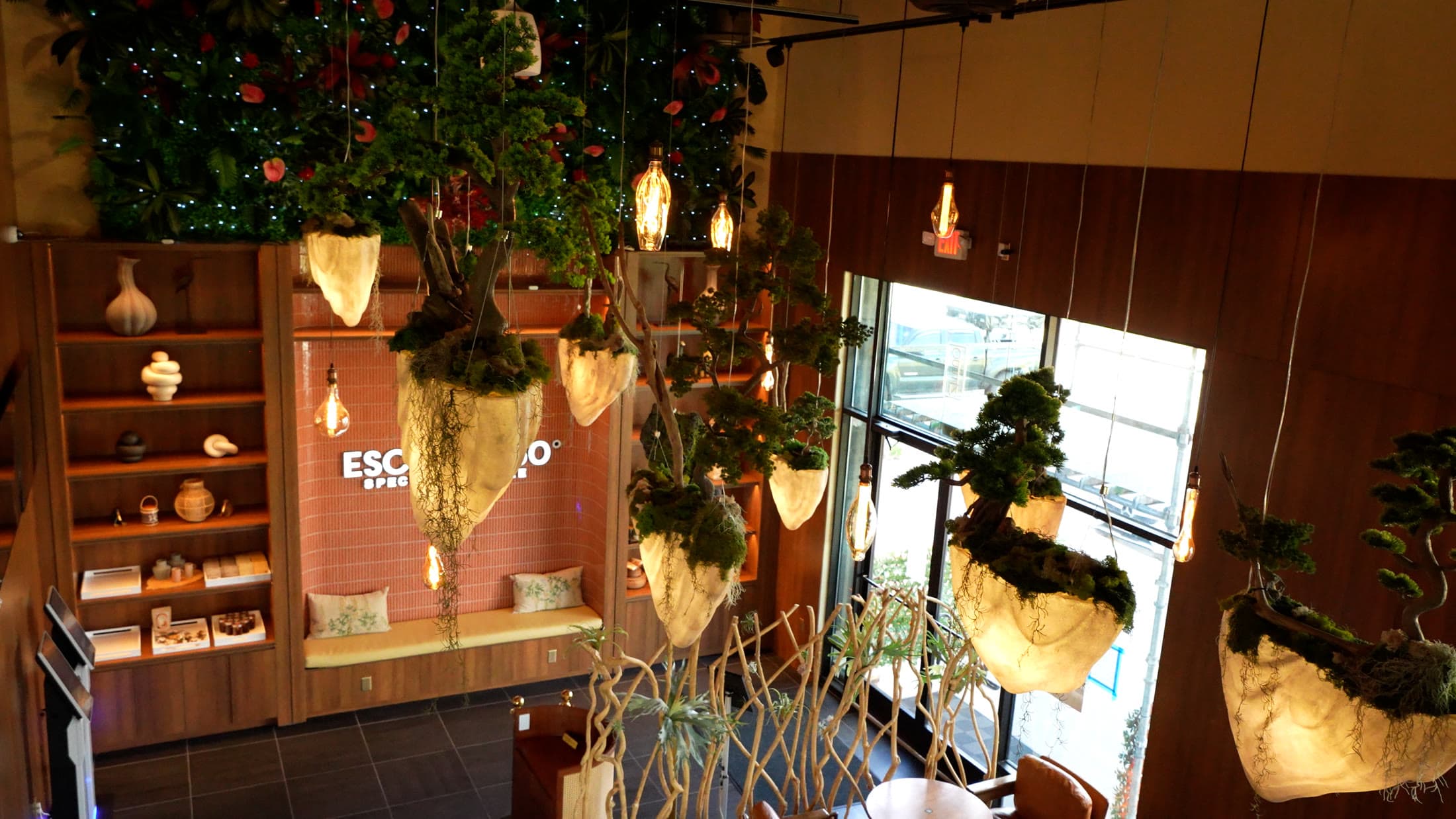 Escape 360 Carrollton — suspended moss pods, Edison lighting, and the living green wall