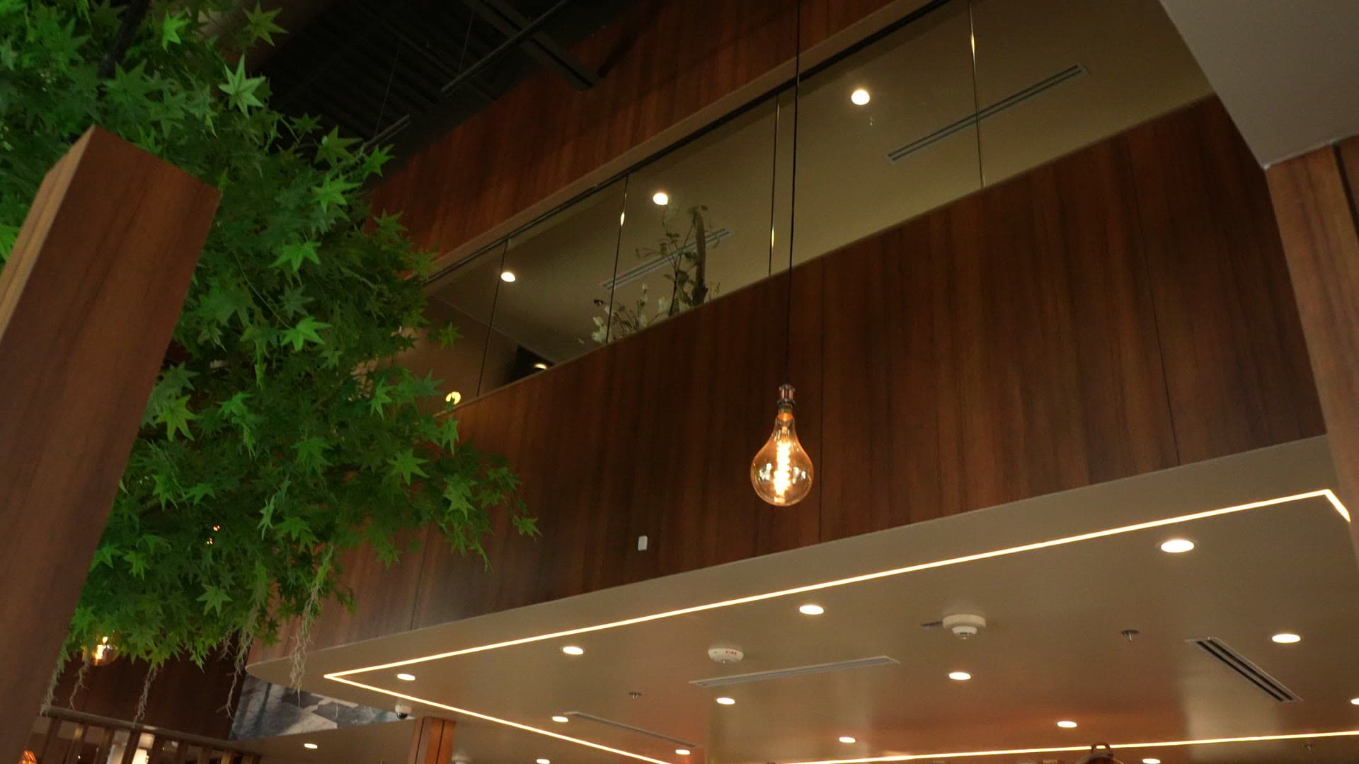 The double-height atrium with an oversized Edison pendant and the upper floor above