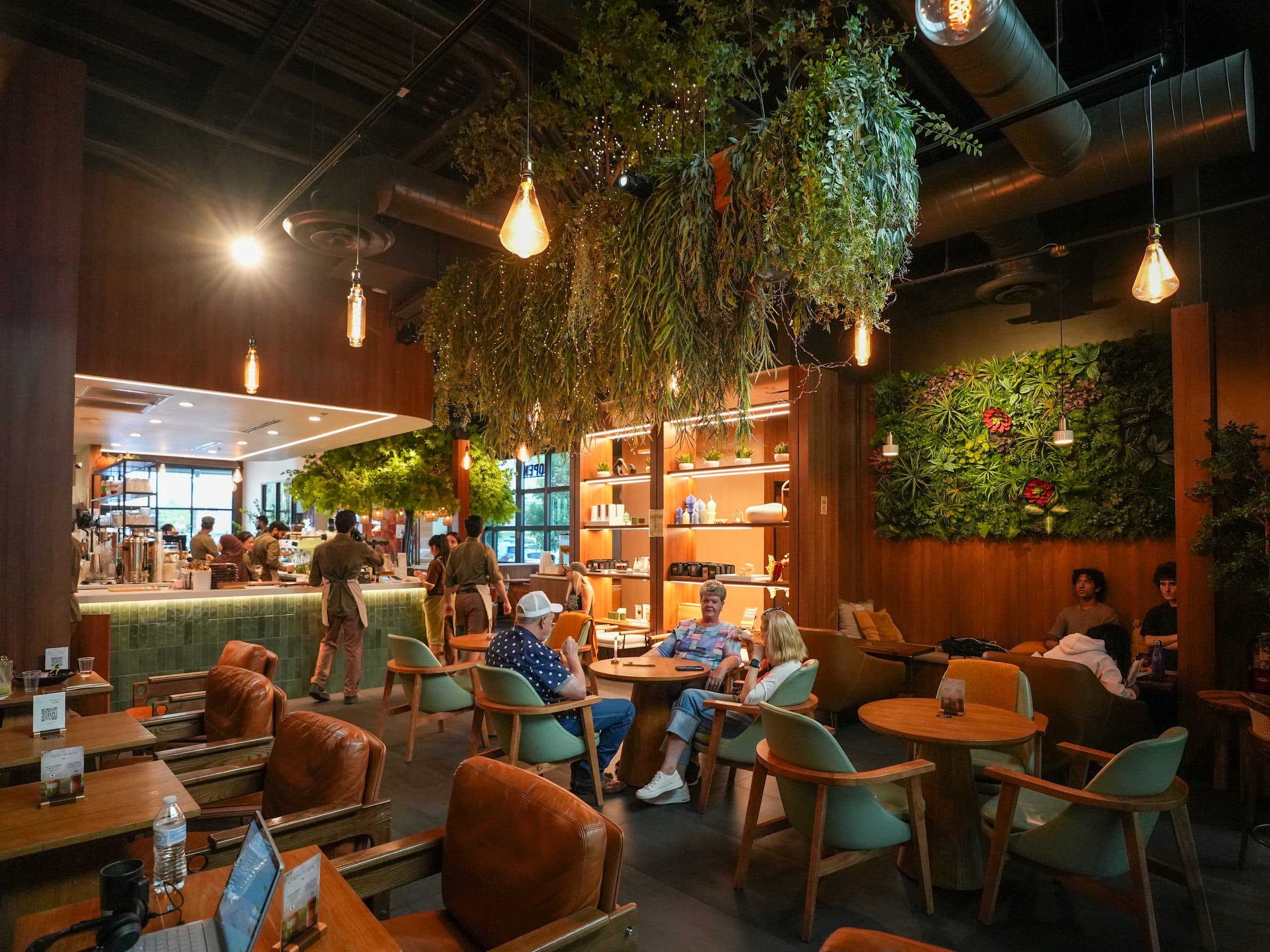 Guests beneath the hanging greenery and living green wall at Escape 360 McKinney