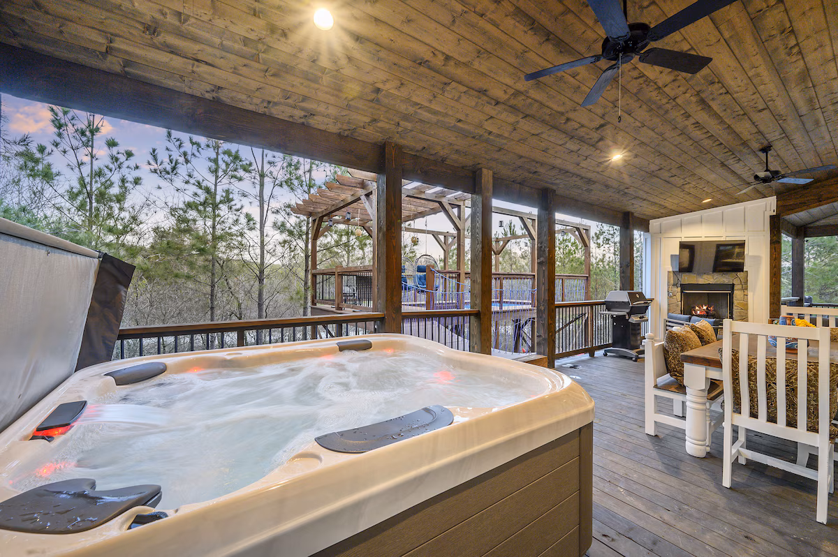 Hot tub on the covered deck with the outdoor fireplace beyond