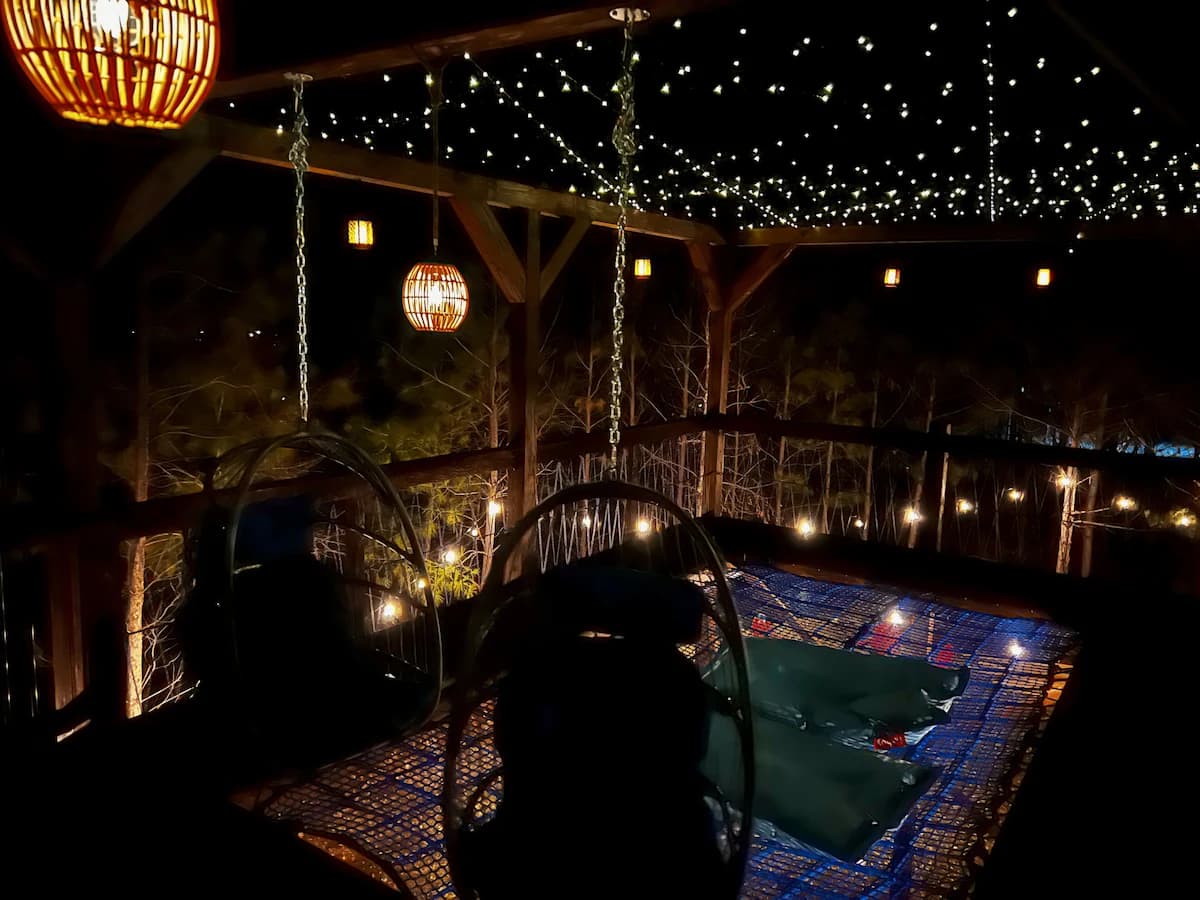 Net lounge under string lights at night